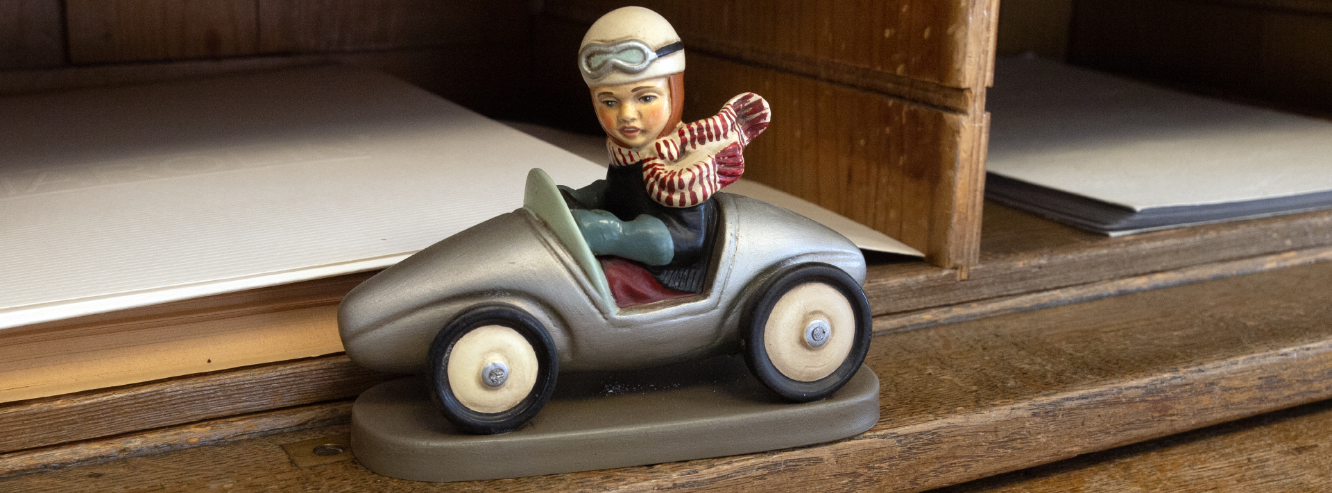 Rennfahrer Dekofigur im silbernen Retro-Spielzeugauto