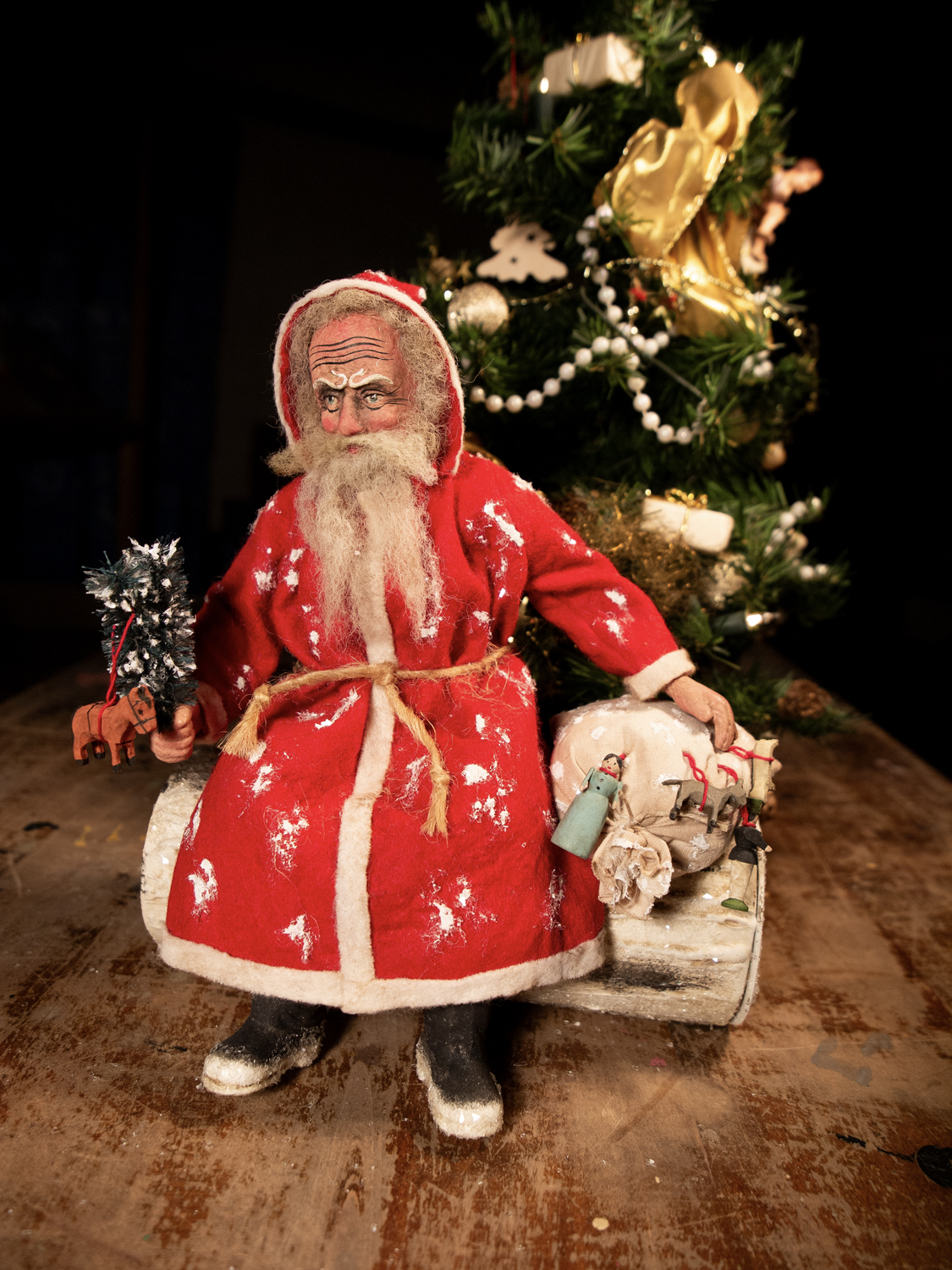 Weihnachtsmann-Dekofigur vor geschmücktem Weihnachtsbaum