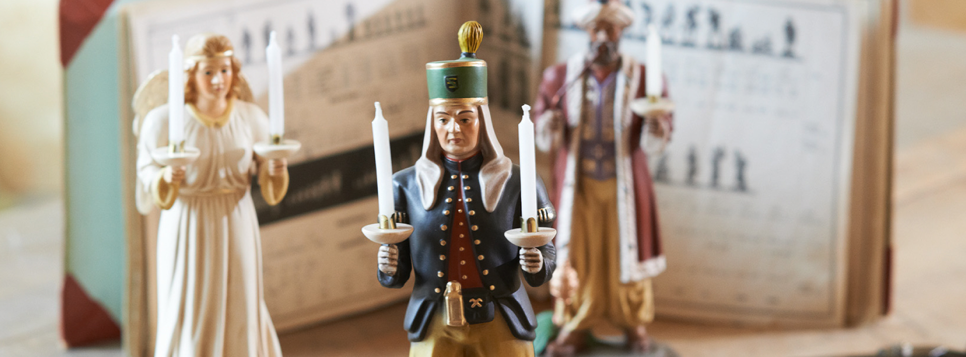 Erzgebirgische Holzfiguren: Bergmann und Engel mit Kerzen