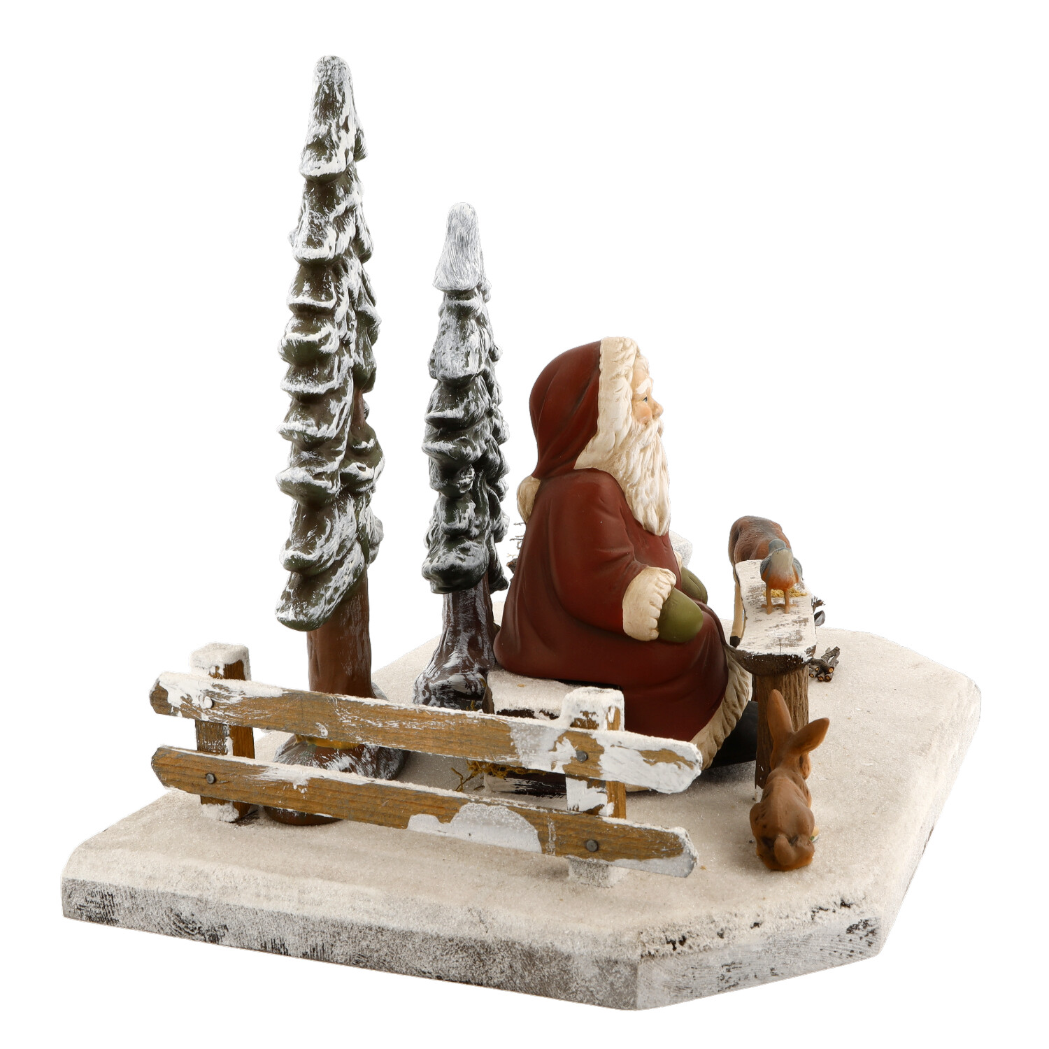 Weihnachtsmann-Figur auf Bank im Winterwald mit Tieren