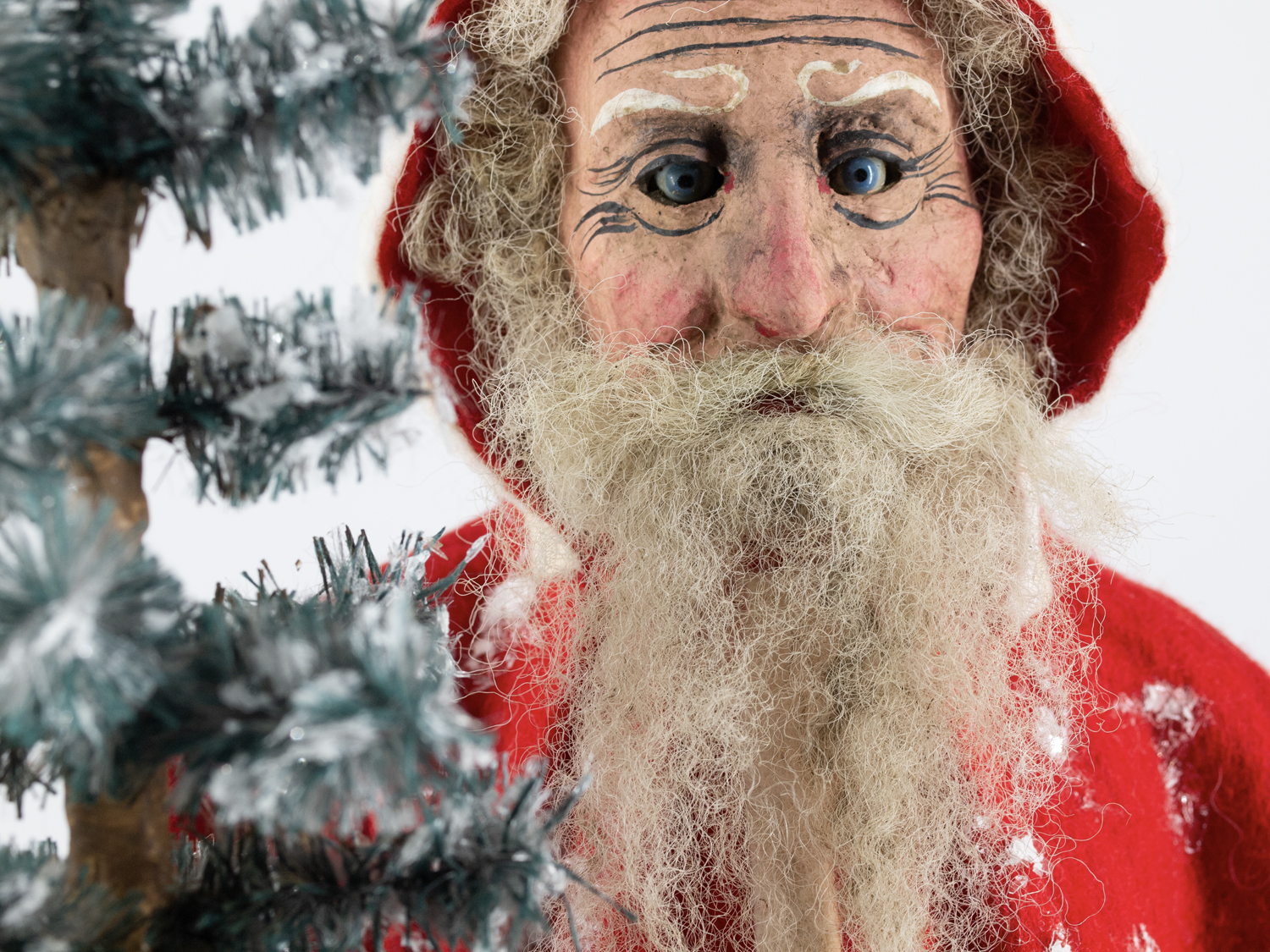 Weihnachtsmann Dekofigur am verschneiten Tannenbaum