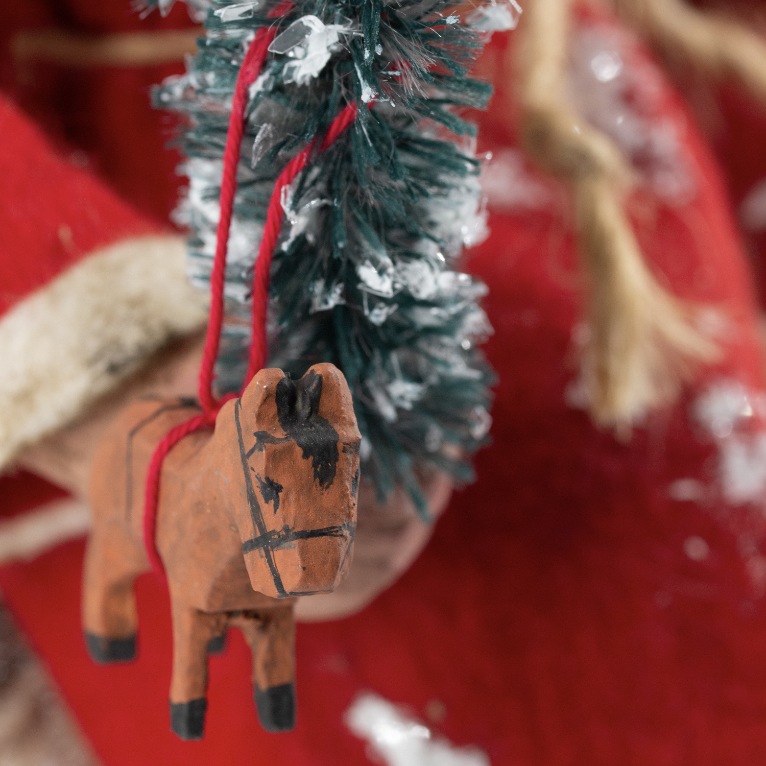 Rustikaler Holz-Pferd-Anhänger an einer Tannengirlande